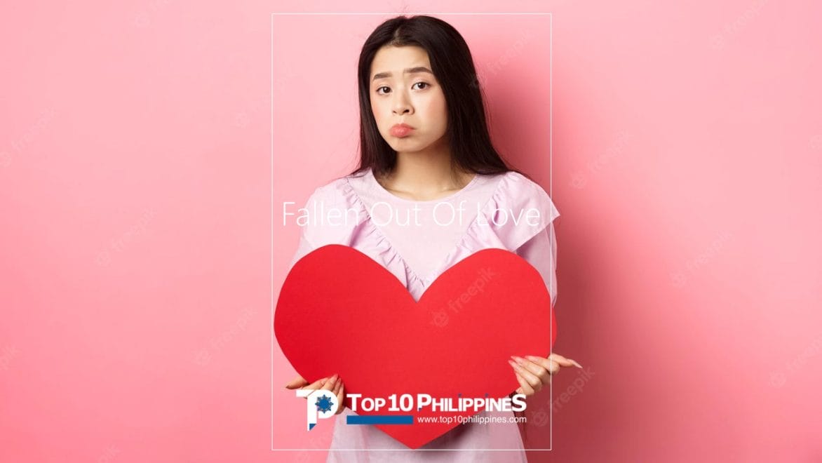 A woman holding a heart cut out and pouting